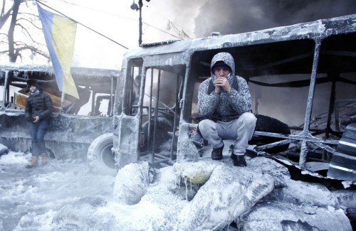 Anti-government protesters gather at a barricade at the site of clashes with riot police in Kiev